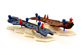 Two ship models with shield and damage pips slotted into them in different configurations.