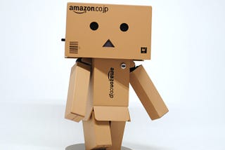 A cardboard creature with fearful expression made of Amazon boxes