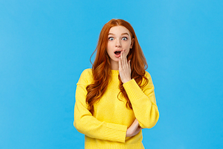 A surprised woman in front of a blue background after hearing memorable marketing message