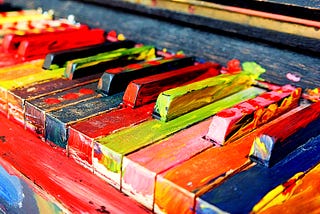 Image of a painted piano. All the keys have some paint on them.