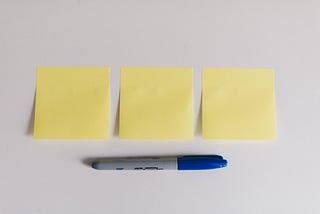 Post-it notes and pen are on a desk ready to use.