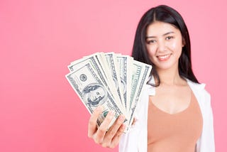 Woman with fanned out hundred dollar bills