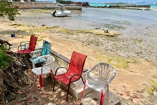 A row of scruffy chairs on a beach