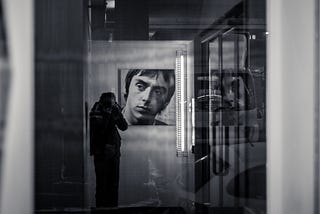 Man taking a photo of Paul Weller in the reflection