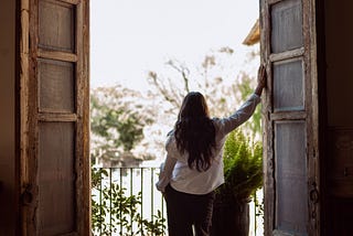 A thoughtful midlife woman walking alone outdoors, appearing calm, self-assured, and comfortable in her own company.