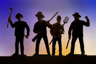Silhouetted mob of four farmers holding an axe, a rifle, a pitchfork, and a stick. By Robert Couse-Baker, CC BY 2.0 <https://creativecommons.org/licenses/by/2.0>, via Wikimedia Common at https://commons.wikimedia.org/wiki/File:Angry_mob_of_four.jpg