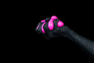 Person holding neon pink goop in their lifted hand