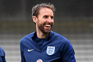 Gareth Southgate smiling wearing England training kit