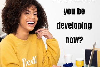 Happy African American Lady siting in front of a computer and an inscription of a question asking “what skill should you be developing now?”