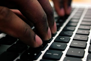 Fingers typing on a laptop keyboard