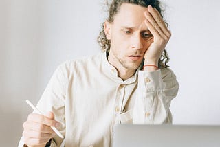 A man stares dumbfounded at a laptop