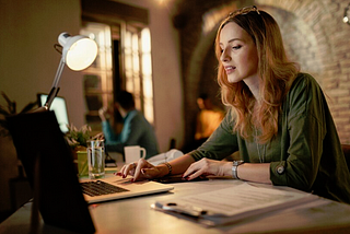 A young woman working on a laptop PC at home.