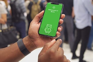 a man’s hands holding a phone showing the citymapper app in a public area