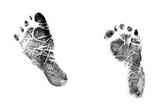 Two ink footprints of a newborns feet on a white background.