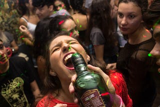 Woman being poured a drink from a bottle at a party