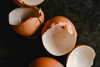 broken eggshells against a dark background
