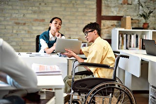 Asian man in a wheelchair at work