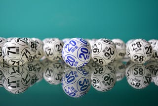 A number of black-and-white lottery balls, with the number 20 in blue