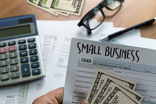 a hand holding a tax form written small business