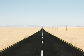 An endless straight road on a desert area