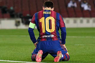 A picture of Lionel Messi kneeling in disappointment after a missed chance at goal.
