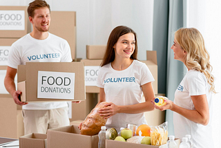 A photo of three young people who are preparing boxes of food donations at a food bank.