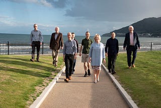 8 people of our team on a coastal path of the Slieve Donard — with the mountains of mourne and the sea in the background