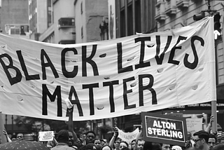 Black Lives Matter protests holding up a “Black Lives Matter” banner in Manhattan