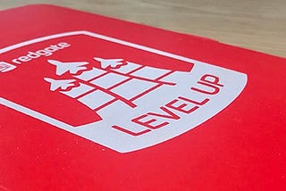 Front cover of a red notebook, with the ‘Redgate Level Up’ logo on it