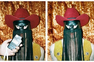 Orville Peck wears a red felt cowboy hat and a yellow vest. His signature leather fringe mask hangs on his face.