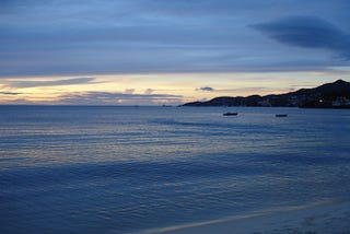 A subtle sunset that makes both the ocean and the sky look a grayish shade of blue.