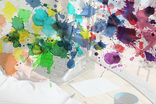 Color splatters on background of a writer with head lay down trying to find the thoughts to write again