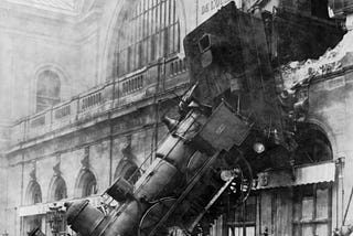 Train wreck at Montparnasse station: train extends through wrecked upper floor wall, awkwardly angled downward towards the street exactly as a train shouldn’t