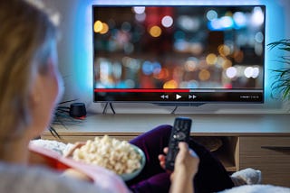 Woman Relaxing at Home in Evening and Watching TV