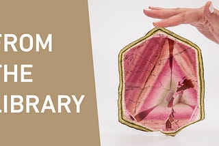 Left side verbiage, From the Library. Right Side, White background, large slice of pink gemstone with woman’s finger holding upright with fingertip on top point.