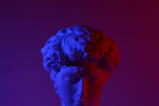 Roman head stone bust, cut off half way under moody purple-pink lighting