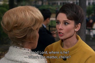 A movie scene showing two people in conversation. With captions displayed reading “- Good Lord, where is he?” and “- What’s the matter, chérie