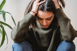 Woman suffering from chronic migraine holding her head in pain.