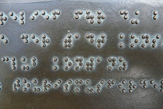 Plat bertulisan braille.