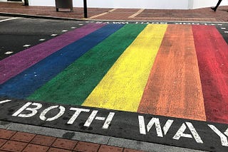 Pelican crossing with a rainbow painted on the road.