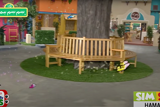A screen grab of the TV show showing a tree surrounded with benches and three animated butterflies, a large yellow, and two small blue and pink flying