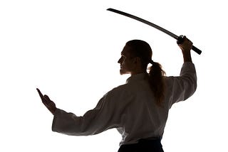 Young man wielding a sword, standing in an aikido pose