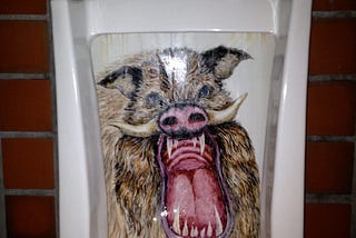 Photo of urinal with an intricate mural of a fierce, angry-looking wild boar painted inside it.