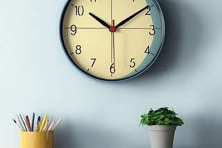 Minimalist office space, white wall with clock and orderly desk