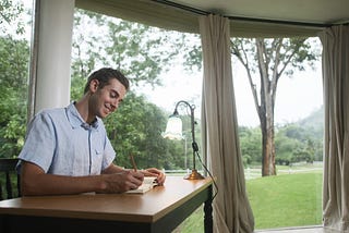 A well-groomed man looking happily at a beautiful pastoral scene from his office window