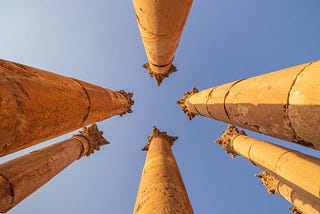On point publishing chosen image of 7 ancient pillar columns streaming upwards towards the sky with the photograph taken from the ground between them all