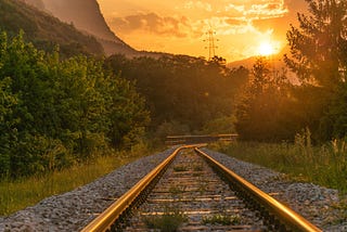 Railroad tracks with sunset in background