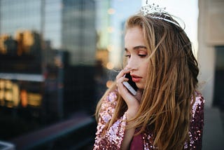 Woman with brown hair using phone outdoors.