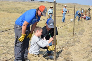 People repairing a fence.