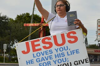 Sidewalk sandwich board carrier with John 3:16.